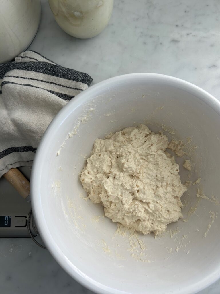 white mixing bowl with sticky dough mixed together