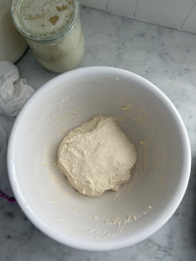 raw dough in a white mixing bowl